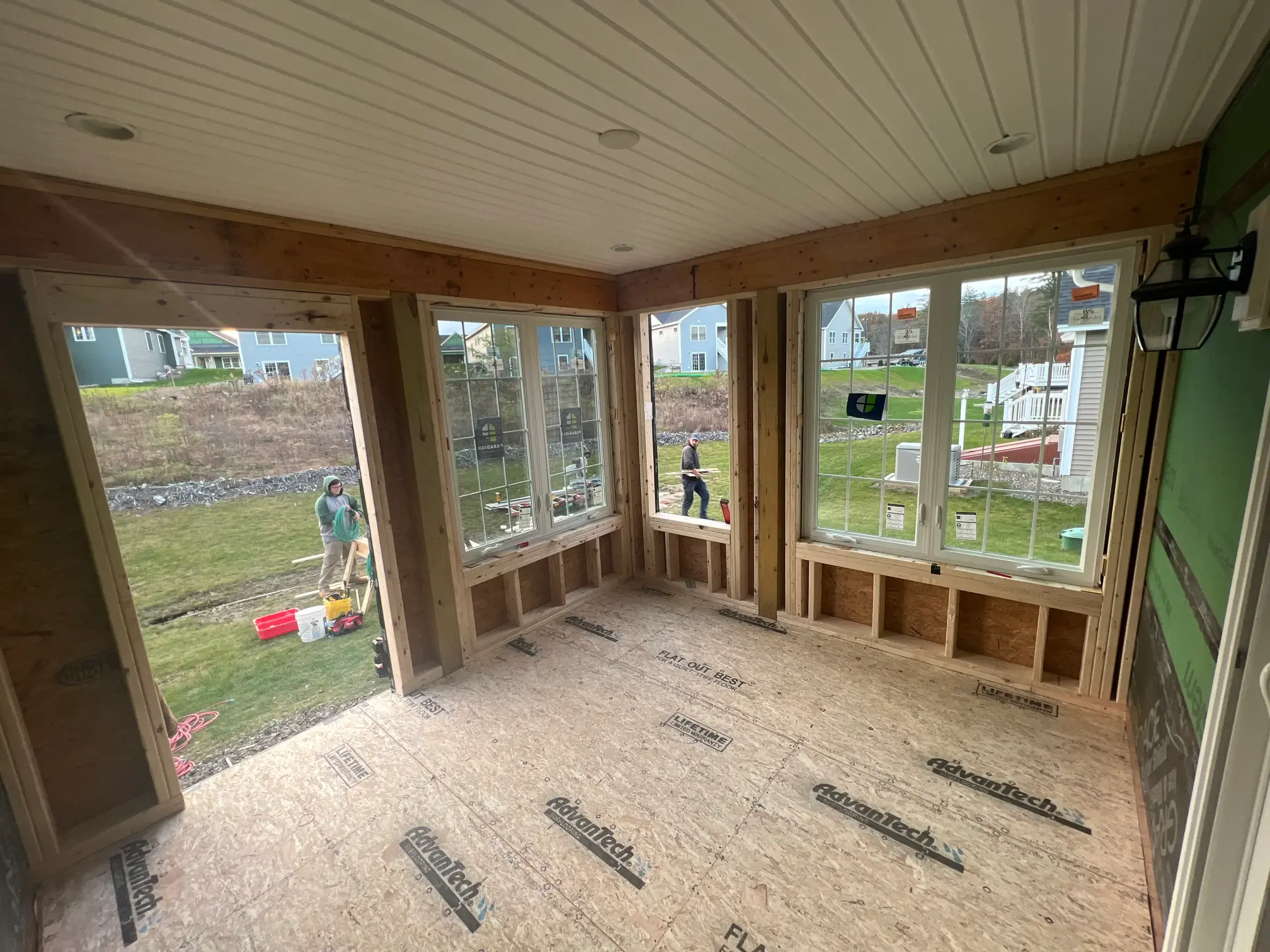 Crew building a covered porch with windows and solid roof