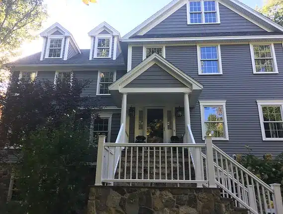 photo of a covered porch with railing and steps leading down to the street level