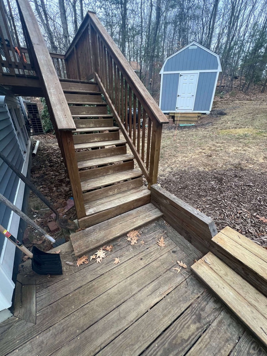 photo of a wooden deck with worn out boards on the deck and steps and railing