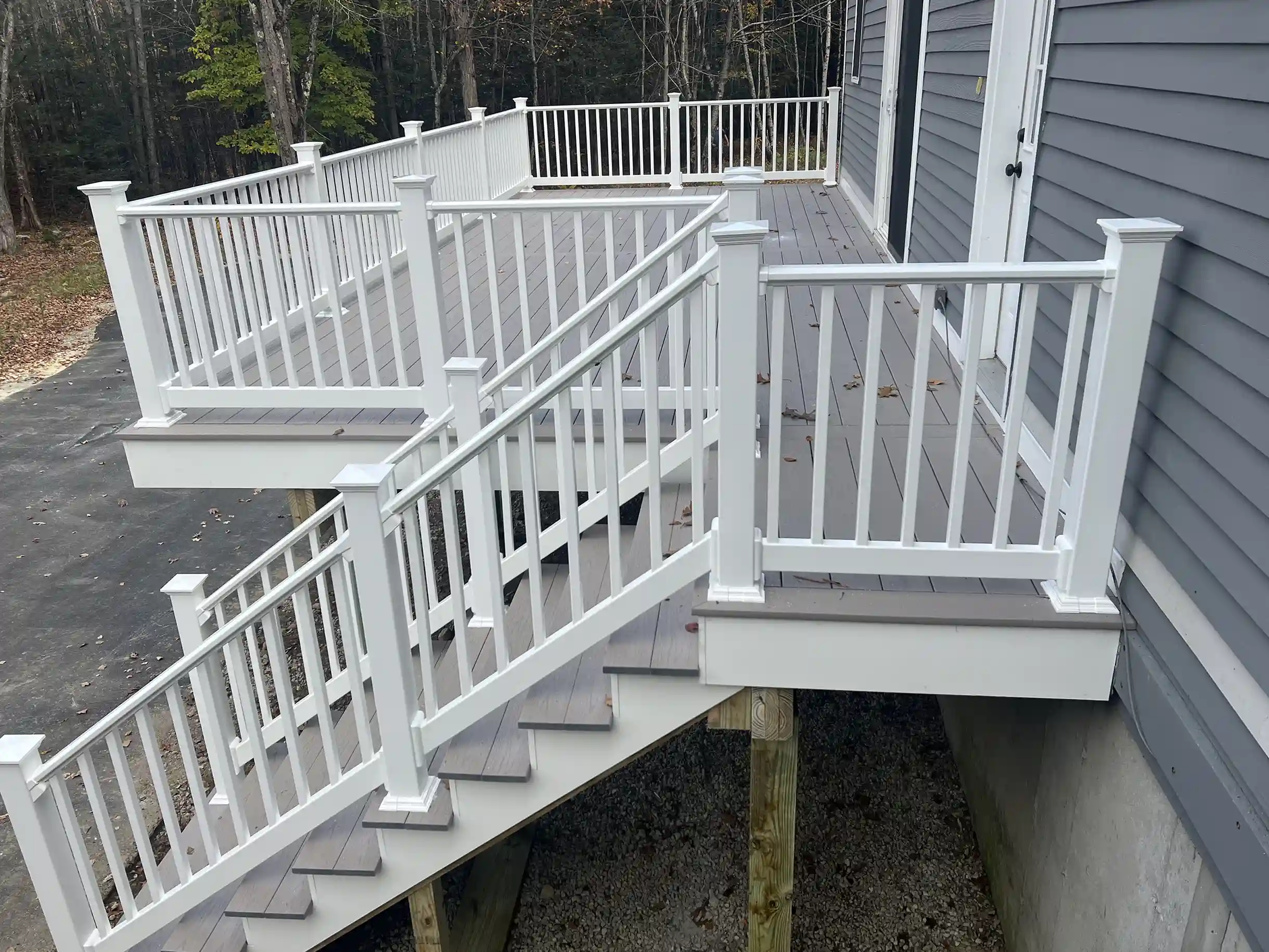Photo of an elevated deck with coastal gray tones, which is one of the deck design trends for this year.